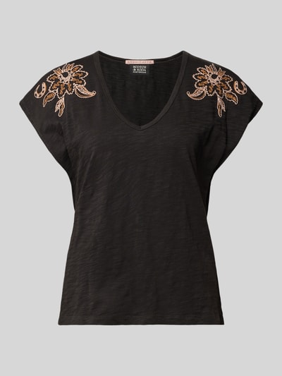 Produktfoto, T-Shirt aus reiner Baumwolle von Scotch & Soda, schwarze Farbe, florale Stickereien an den Schultern, taillierte Passform, Rundhalsausschnitt, Rückenlänge bei Größe S beträgt 61 cm, leichte Struktur der Oberfläche erkennbar.
