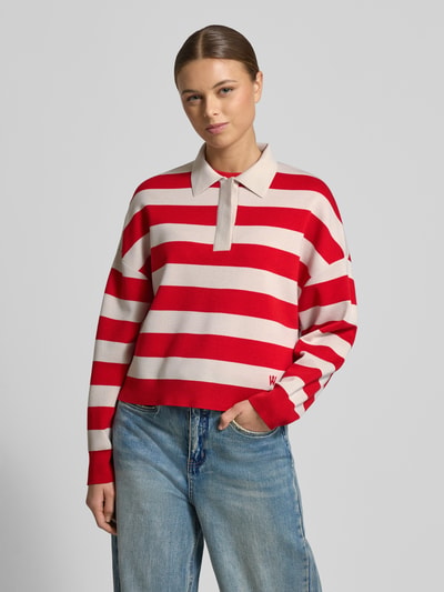 Frauenmodel trägt Regular Fit Longsleeve aus reiner Schurwolle mit Polokragen von Windsor, rot-beige gestreift, Strick-Optik, Nahaufnahme Oberkörper.