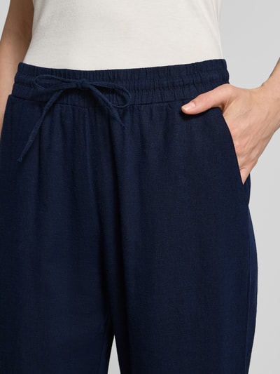 Vrouwenmodel draagt Wide Leg Pants aus Leinen-Mix met elastischem Bund Modell 'Lava' van FREE/QUENT, marineblauw, met linnenmix, loose fit, detailopname taille met tunnelkoord, bandwijdte maat S 40 cm, binnenbeenlengte 67 cm.