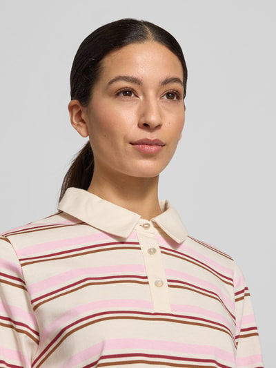 Frauenmodel trägt Poloshirt aus reiner Baumwolle von Soyaconcept, gestreift in Creme, Rosa und Braun, Nahaufnahme Oberkörper.