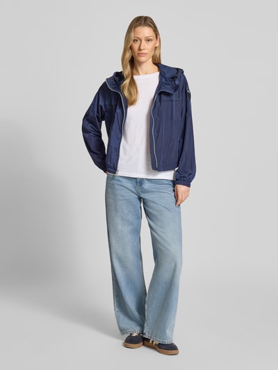 Frauenmodel trägt blaue Trekking Jacke mit Kapuze Modell 'BURRAGE' von Blauer Usa, gerader Schnitt, Ganzkörperansicht von vorne