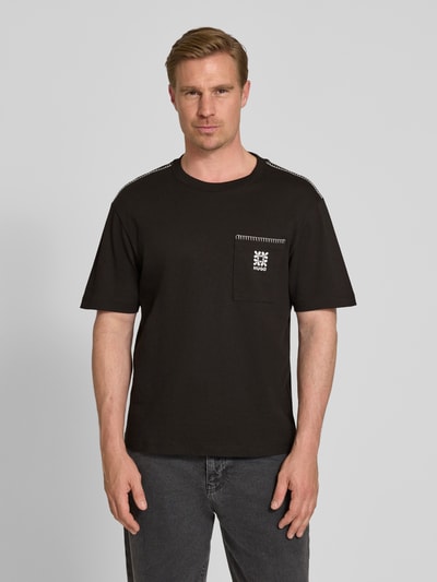 Männermodel trägt Regular Fit T-Shirt aus reiner Baumwolle Modell 'DARRO' von HUGO, Optik: Unifarben, Label-Schriftzug, Rundhals, Kurzarm, Jersey, Ganzkörperansicht von vorne.