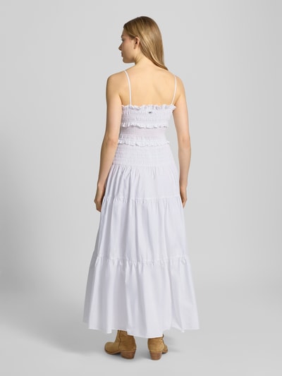 Frauenmodel trägt Midikleid mit Rüschen und Volantsaum von MICHAEL Michael Kors in Weiß, reine Baumwolle, tailliert, Ganzkörperansicht Rückansicht.