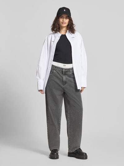 Frauenmodel trägt Relaxed Fit Hemdbluse mit Logo-Stitching von Karo Kauer aus Reine Baumwolle, weiß, Langärmelig, Ganzkörperansicht von vorne.