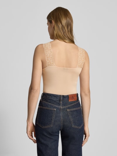 Frauenmodel trägt Slim Fit Tank Top aus Viskose-Mix Modell 'BARBERA LACE' von Pieces in Beige, unifarben, breite Spitzenträger, Karree-Rückenausschnitt, Jersey-Textur, Ganzkörperansicht Rückansicht.