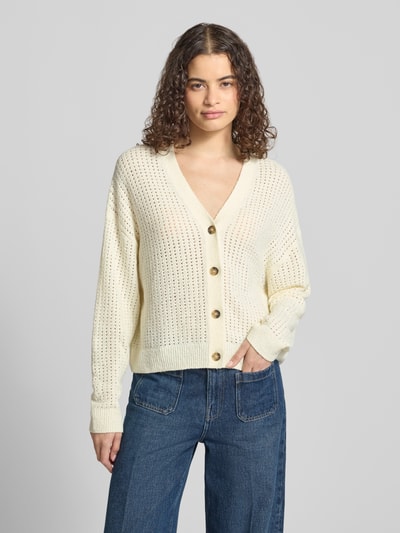Frauenmodel trägt Relaxed Fit Strickjacke aus Baumwoll-Mix von Marc O'Polo DENIM in Creme mit grober Lochstruktur, Nahaufnahme Oberkörper.