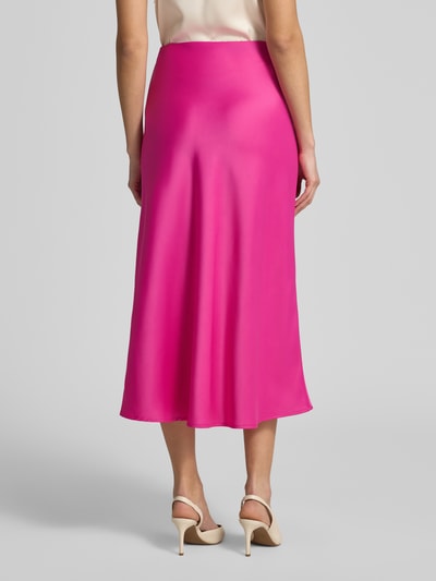 Frauenmodel trägt Midirock mit elastischem Bund Modell 'YASPELLA' von YAS, kräftiges Pink, glatte Textur, A-Linie, Ganzkörperansicht Rückansicht.