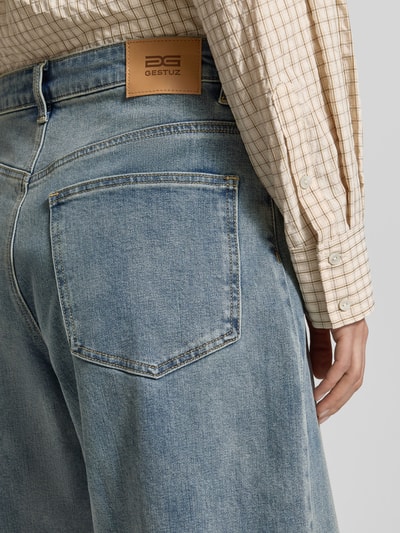 Frauenmodel trägt Wide Leg Jeansshorts im 5-Pocket-Design von Gestuz aus blauem Baumwoll-Mix, Detailaufnahme Rückansicht. Bundweite 39 cm, Innenbeinlänge 26 cm, Elastischer Baumwoll-Mix, Knopf- und Reißverschluss.