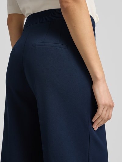 Frauenmodel trägt Stoffhose mit weitem Bein und Bügelfalten von Betty Barclay in Dunkelblau, Material-Mix, Detailaufnahme Rückansicht.