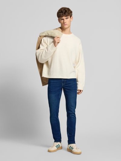 Männermodel trägt Slim Fit Jeans aus Baumwoll-Mix Modell 'LOOM' von Only & Sons in Dunkelblau, 5-Pocket-Design, Ganzkörperansicht von vorne.