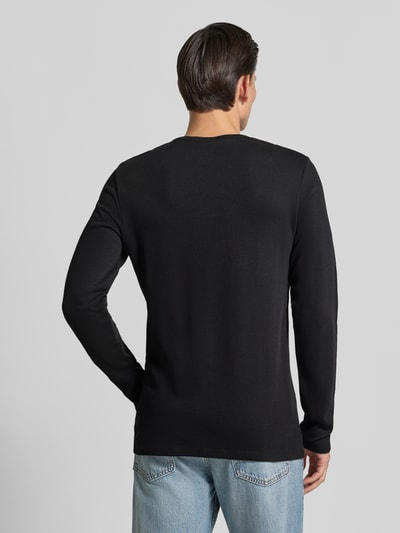 Männermodel trägt Regular Fit Longsleeve aus reiner Baumwolle Modell 'Basic' von Lindbergh in Schwarz, glatte Struktur, Ganzkörperansicht Rückansicht. Rückenlänge bei Größe M: 73 cm.