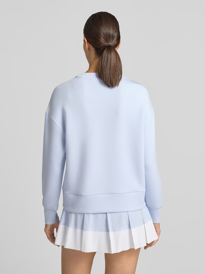 Frauenmodel trägt Sweatshirt aus Viskose-Mix Modell 'rasco' von VARLEY in Hellblau mit elastischen Abschlüssen, Ganzkörperansicht Rückansicht.