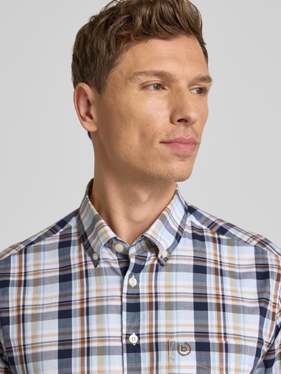 Männermodel trägt Freizeithemd mit Knopfleiste von bugatti, reine Baumwolle, Regular-Fit, Button-Down-Kragen, Nahaufnahme Oberkörper.