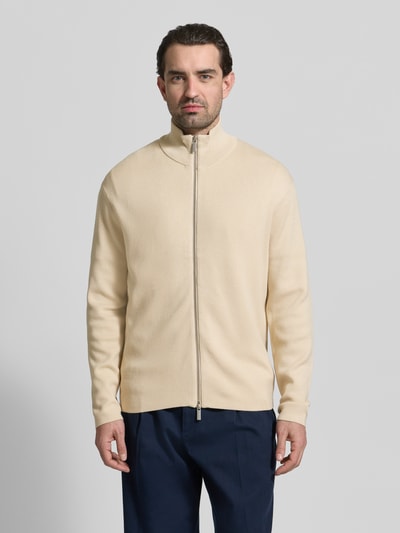 Männermodel trägt Relaxed Fit Strickjacke aus Viskose-Mix Modell 'TELLER' von SELECTED HOMME in Creme, Feinstrick, Ganzkörperansicht von vorne.