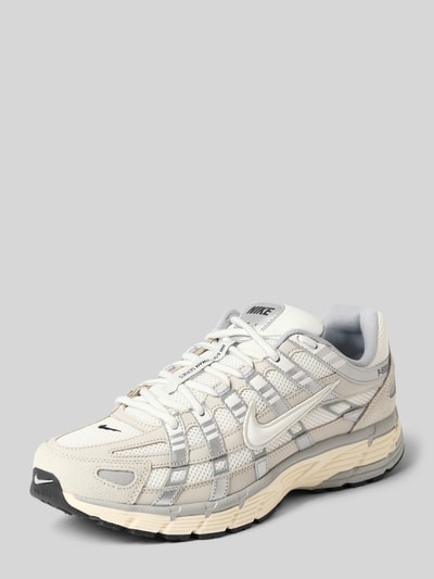 Produktfoto, Sneaker mit Logo-Detail von Nike in Beige und Grau, abgerundete Passform, Schnürverschluss, profilierte Sohle, Absatzhöhe 5 cm, Schafthöhe 8 cm, Schaftweite 7 cm, dezente Struktur und Logo-Detail sichtbar.
