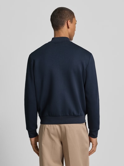 Männermodel trägt Regular Fit Bomberjacke aus Baumwoll-Mix von Marc O'Polo in Dunkelblau, Optik: Unifarben, Ganzkörperansicht Rückansicht.