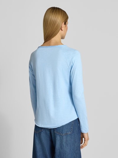 Frauenmodel trägt Longsleeve mit Rundhalsausschnitt von Smith and Soul aus reiner Baumwolle in Hellblau, Regular-Fit, Rollsaum, Rückenlänge 60 cm, Ganzkörperansicht Rückansicht.