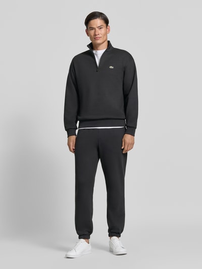 Mannenmodel draagt zwarte Regular Fit schipperstrui uit katoenmix van Lacoste, Heren Troyer, volledige lichaamsvooraanzicht.