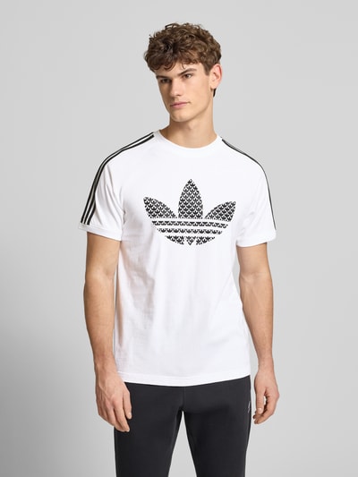 Męski model nosi T-Shirt mit Label-Stitching od adidas Originals, biała bawełna, regular fit, widok całej sylwetki z przodu.