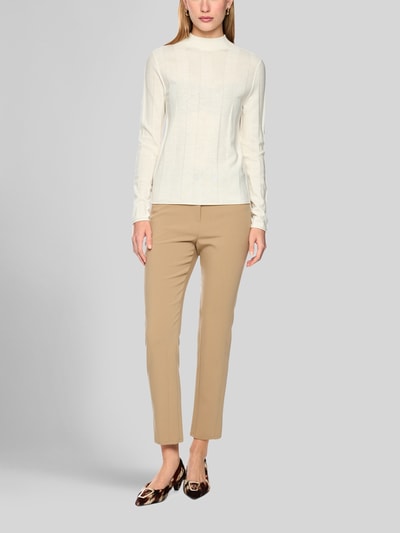Frauenmodel trägt Strickpullover aus Schurwolle-Mix mit Stehkragen von Marc Cain, schmal geschnitten, helles Beige, Ganzkörperansicht von vorne. Damen Strickpullover, Kaschmir-Anteil, Label-Detail, Rückenlänge 55 cm, Ärmellänge 66 cm.