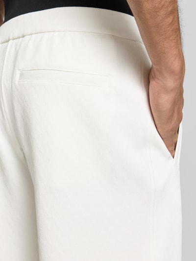 Männermodel trägt Wide Fit Sweatpants mit Lyocell-Anteil von Emporio Armani in Weiß, elastischer Bund, Eingrifftasche, Detailaufnahme Rückansicht.