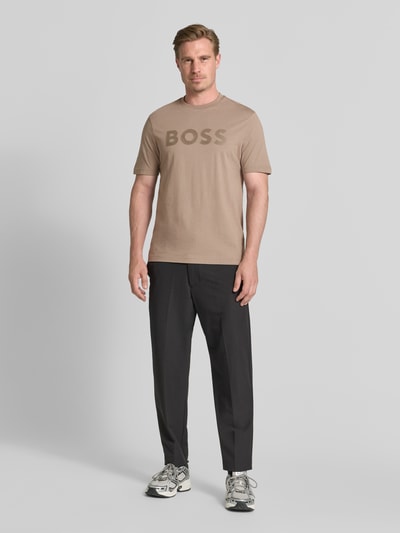 Męski model nosi Regular Fit T-Shirt aus reiner Baumwolle Modell 'TS_STRUCTURE LOGO 1027473' od BOSS Green, beż i czerń, gładka faktura, Ganzkörperansicht von vorne.