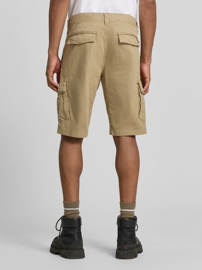 Männermodel trägt Bermudas mit Pattentaschen und Label-Stitchings von PME Legend in Beige, Straight Fit, Detailaufnahme Rückansicht. Bundweite bei Größe 32: 41 cm, Innenbeinlänge bei Größe 32: 26 cm, seitliche Eingrifftaschen, Gesäßtaschen, Knopf- und Reißverschluss, Label-Details.