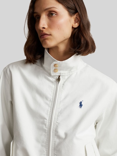 Modelka prezentuje Regular Fit Blouson aus reiner Baumwolle von Polo Ralph Lauren, biały kolor, logo z przodu, krój regular fit, zbliżenie na górną część ciała.