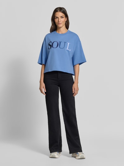 Frauenmodel trägt Cropped Boxy Fit Sweatshirt mit Label-Stitching von Smith and Soul in Blau, Rundhalsausschnitt, 1/2-Arm, Baumwoll-Elasthan-Mix, Ganzkörperansicht von vorne.