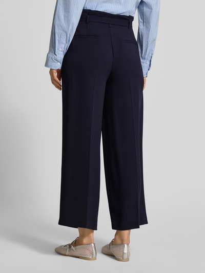 Frauenmodel trägt Regular Fit Stoffhose mit Gürtel von Windsor, dunkelblau, Material-Mix, Bügelfalten, Rückansicht, Ganzkörperansicht.