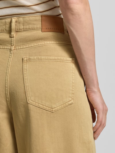 Frauenmodel trägt Wide Leg Jeans im 5-Pocket-Design von Stefanel in Beige, reine Baumwolle, ausgestellter Schnitt, Detailaufnahme Rückenansicht.