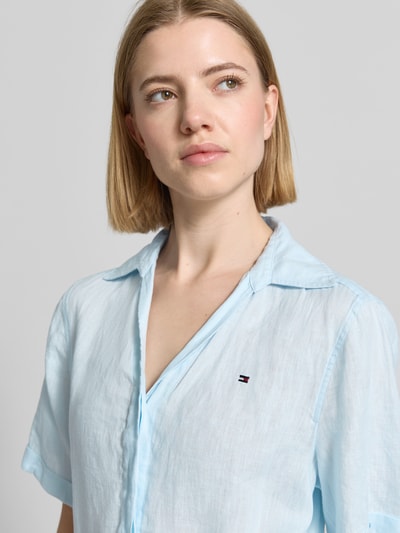 Frauenmodel trägt Ausgestelltes Freizeitkleid aus reinem Leinen von Tommy Hilfiger in hellblau, unifarbene Optik, Hemdblusenkragen, Logo Stitching, Nahaufnahme Oberkörper.