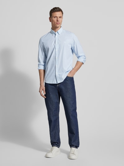 Männermodel trägt Regular Fit Freizeithemd aus reiner Baumwolle von Marc O'Polo mit Allover-Streifenmuster in Hellblau, Ganzkörperansicht von vorne.