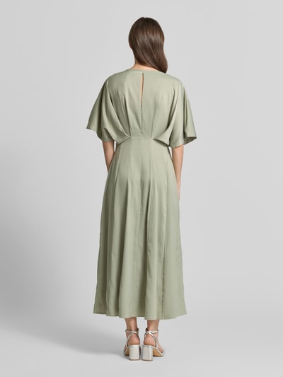 Vrouwenmodel draagt Midikleid mit V-Ausschnitt Modell 'VIANNA' van Copenhagen Muse in lichtgroen, getailleerde fit, draperieën, ruglengte 130 cm, borstwijdte 40 cm, mouwlengte 28 cm, volledige rugaanzicht.