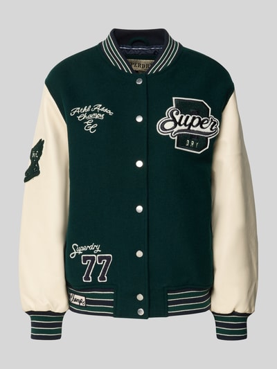 Produktfoto, College Jacke mit Motiv- und Logo-Stitchings von Superdry, Woll-Mix in Dunkelgrün mit cremefarbenen Ärmeln, lockerer Schnitt, kurzer Stehkragen, Druckknopfverschluss, elastische Abschlüsse, Stickereien und Applikationen im College-Stil