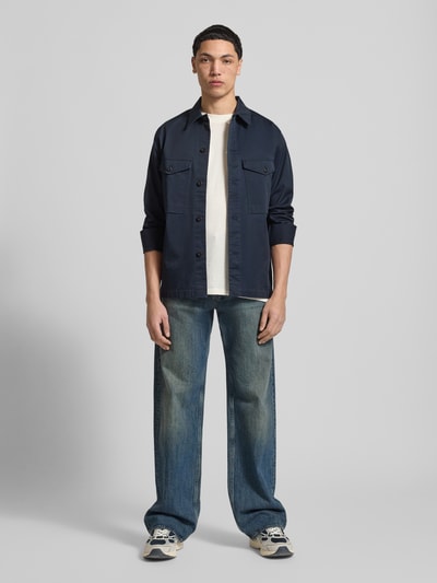 Männermodel trägt Regular Fit Hemdjacke mit borstzakken van G-Star Raw in donkerblauw katoenmix, met lange mouwen en kentkraag, knoopsluiting; ruglengte maat M 70 cm, schouderbreedte 45 cm, mouwlengte 66 cm. Ganzkörperansicht von vorne.