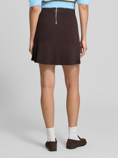 Vrouwenmodel draagt Ausgestellter Mini-Rock aus Viskose-Mix model 'SABA' van VERO MODA in donkerbruin met grove textuur, Ganzkörperansicht Rückansicht. Dames minirok