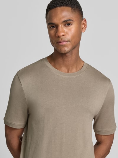 Męski model nosi Regular Fit T-Shirt mit Rundhalsausschnitt Modell 'Badi' von CINQUE z bawełny, elastyczne zakończenia rękawów, długość tyłu 68 cm w rozmiarze M, kolor beżowy, gładka faktura, zbliżenie na górną część ciała, ujęcie z przodu.
