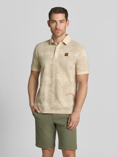 Mężczyznamodel nosi Slim Fit Poloshirt mit Label-Patch von PME Legend, beżowy kolor, czysta bawełna, allover-wzór, krój slim fit, długość tyłu w rozmiarze M: 74 cm, widok cała sylwetka z przodu.