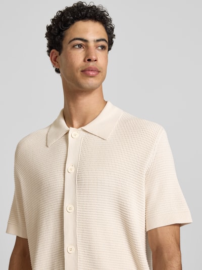 Männermodel trägt Regular Fit vrijetijdsoverhemd van Marc O'Polo Denim in effen kleuren, knitwear van puur katoen, labelpatch, polokraag, V-hals, knoopsluiting, korte mouw, geribde mouw- en rompzoom. Nahaufnahme Oberkörper.