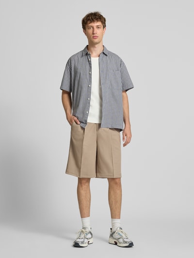 Mannelijk model draagt Loose Fit Chinoshorts met viscose van Only & Sons in beige, zachte structuur, heren, full-body vooraanzicht.