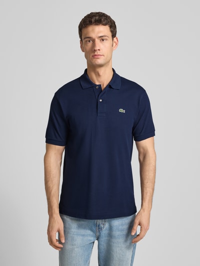 Männermodel trägt Poloshirt mit Label-Stitching Modell 'L.12.12 CORE' von LACOSTE in Unifarben Regular-Fit aus reiner Baumwolle, Ganzkörperansicht von vorne.