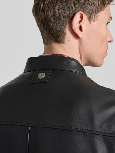 Männermodel trägt schwarze Lederjacke mit Stehkragen aus Schafsleder, Modell 'JORK' von Mauritius, Detailaufnahme Rückenansicht.