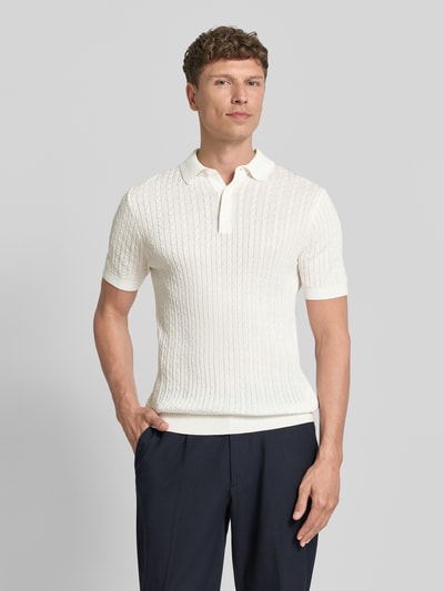 Mężczyznamodel nosi Regular Fit Poloshirt aus reiner Baumwolle Modell 'ADRIAN-CA' von Strellson, kremowy kolor, krótki rękaw, faktura dzianiny, wzór warkoczowy, polo kołnierzyk, krótka listwa guzikowa, widok całej sylwetki z przodu.