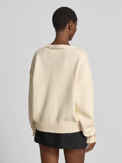 Frauenmodel trägt Oversized Pullover in Strick-Optik von black palms aus Baumwoll-Mix, elastische Abschlüsse, Rückenlänge 64 cm, Ganzkörperansicht Rückansicht.