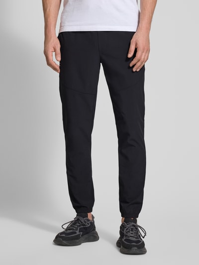 Männermodel trägt schwarze Regular Fit Sweatpants mit Logo-Print Modell 'Vibe' von Under Armour, Elastischer-Material-Mix, Ganzkörperansicht von vorne.
