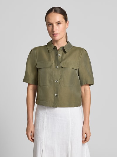 Frauenmodel trägt Regular Fit Bluse aus Lyocell-Mix mit Brusttaschen von MORE & MORE in Olivgrün, Knopfleiste, Hemdblusenkragen, Leinen-Anteil, Ganzkörperansicht von vorne.