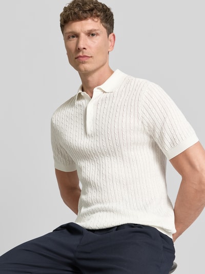 Męski model nosi Regular Fit koszulkę polo z czystej bawełny model 'ADRIAN-CA' od Strellson, imitacja dzianiny, ścieg warkoczowy, kołnierzyk polo, krótki rękaw, dekolt w serek, listwa guzikowa, materiał: dzianina z bawełny, widok na górną część ciała z przodu.