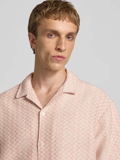 Männermodel trägt Regular Fit Freizeithemd im Allover-Look Modell 'MONTAUK' von Jack & Jones aus Material-Mix mit Baumwoll-Anteil, Reverskragen, dezentes Muster in Rosa und Weiß, Knopfleiste, strukturierte Textur, Nahaufnahme Oberkörper. Rückenlänge bei Größe M 71 cm, Schulterbreite 50 cm, Ärmellänge 22 cm.