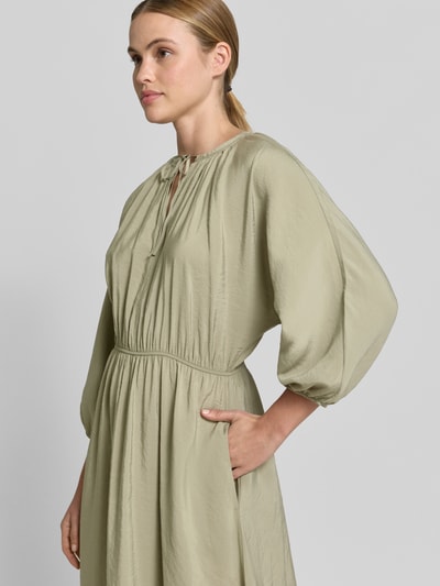 Frauenmodel trägt Midikleid mit Eingrifftaschen Modell 'Worty' von OPUS in hellem Beige, A-Linie, Modal-Mix, Nahaufnahme Oberkörper.